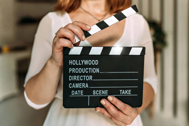 istock A woman in her hands holds a black board with a clapperboard while shooting a film, video. Cinema tablet in video production. Take, storyboard, frame 1344961773