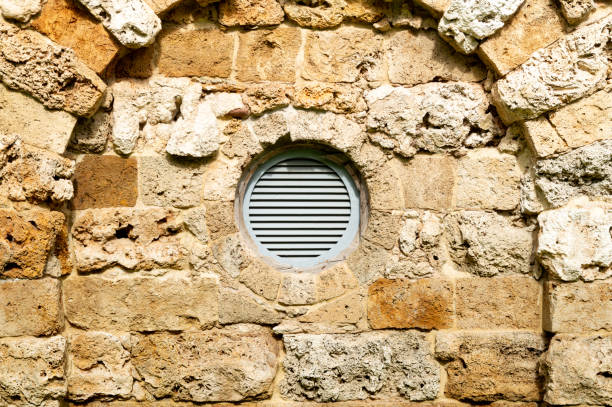 round plastic ventilation grate in the stone wall. High quality photo