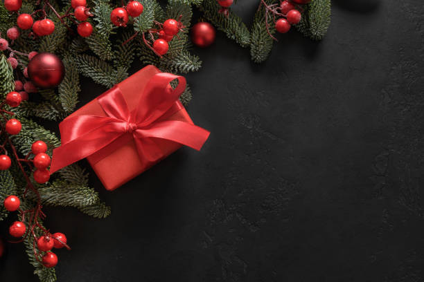 istock Christmas frame with red gift and decorations on black. Xmas greeting card. 1344965118
