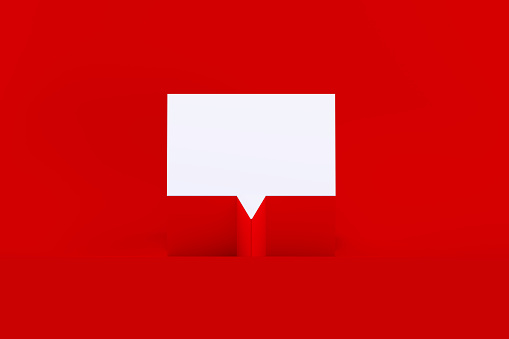 White speech bubble sitting on red background. Horizontal composition with copy space.