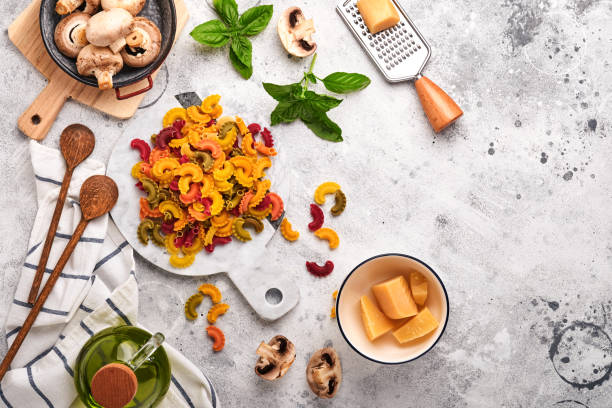 pasta. italian pasta. insalata di pasta and vegetables cooking ingredients, cheese, mushrooms and basil on old stone background. italian food cooking ingredients. top view with copy space. - cooking oil olive oil nutritional supplement spoon imagens e fotografias de stock