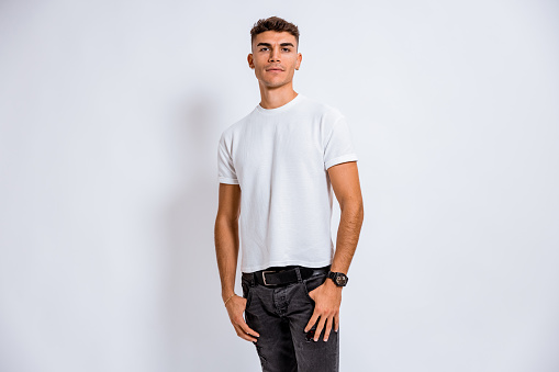 One teenage boy posing on white background for a studio shot.