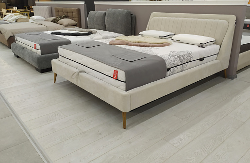 Modern luxury beds in the mall. Furniture store. Sale of beds and sofas.Sale, discounts