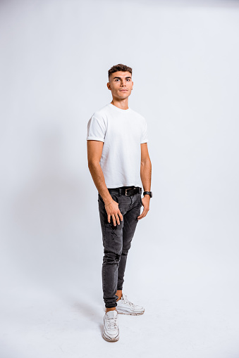 One teenage boy posing on white background for a studio shot.
