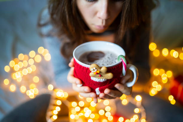 istock Young woman blowing a cup of coffee 1344972141