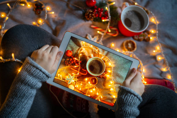 istock A pair of hands holding a digital screen showing a festive display underneath 1344972209