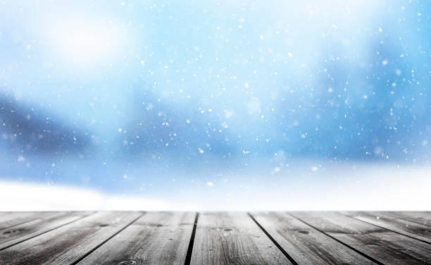 istock Wooden planks against a blurred background with snowflakes 1344973190