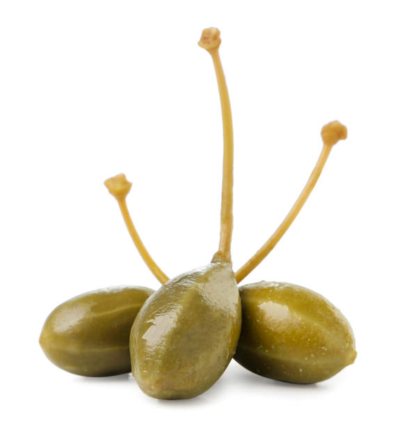 Three pickled capers with tails on a white background. Isolated Three pickled capers with tails close-up on a white background. Isolated caper stock pictures, royalty-free photos & images