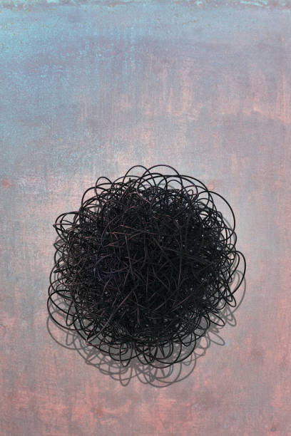 istock Tangled black cable floating mid air on a textured wall 1344973340