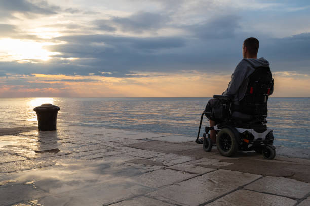 istock Wheelchair at sunset in sea 1344974777
