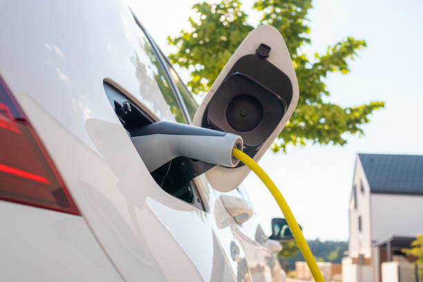 istock Electric car with charger plugged in 1344977122