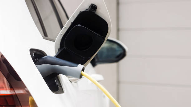 istock Electric car with charger plugged in 1344977289