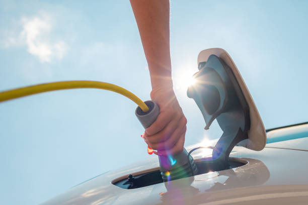istock Female hands plugging in the EV charger 1344977321