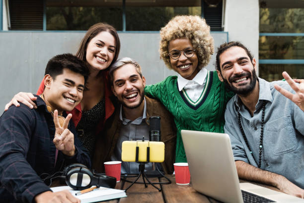 istock Happy people streaming live podcast online using microphone and laptop computer outdoor - Main focus on african woman face 1344977968