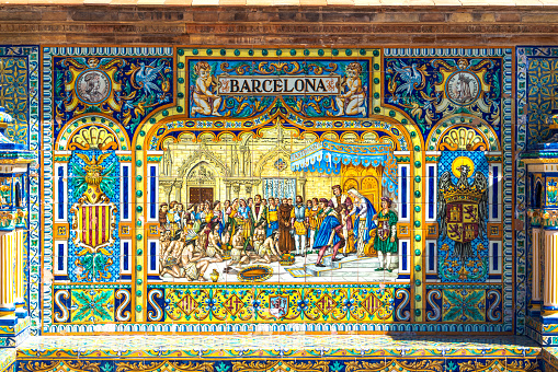 Sevilla, Spain - July 14, 2021: Historic tile bench from the Plaza de Espana in Sevilla, Spain with Columbus and Native Americans. The Plaza de Espana was built in 1928 for the Ibero-American Exposition of 1929 and has different cities represented all around the plaza.