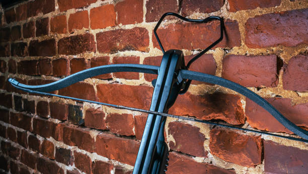 istock A modern compound crossbow handgun on the red brick wall background. Old weapon concept. 1344978524