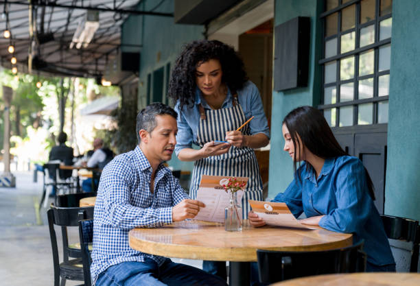 istock Waitress working at a restaurant and taking the order of two customers 1344979161