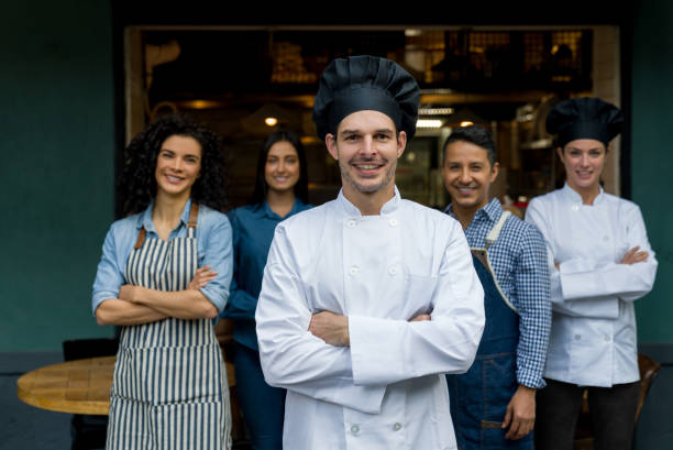 istock Chef leading his staff at a restaurant and looking very happy 1344979169