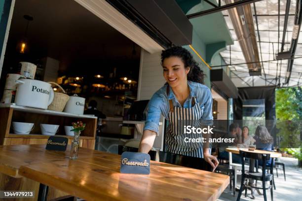 Waitress Putting A Reserved Sign On A Table At A Restaurant Stock Photo - Download Image Now