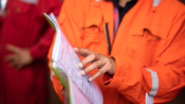 Action of a supervisor pointing on document paper in safety audit.