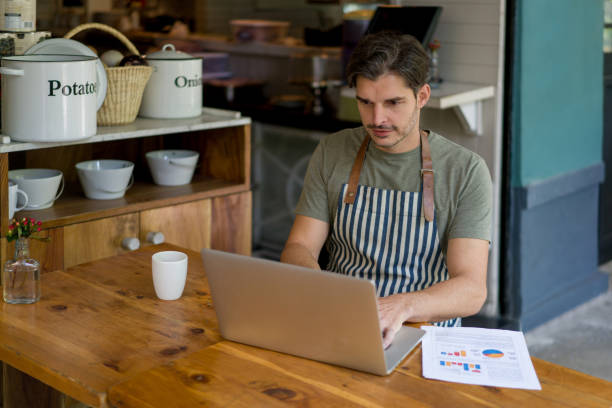 istock Waiter working at a restaurant closing his shift doing the books 1344979229