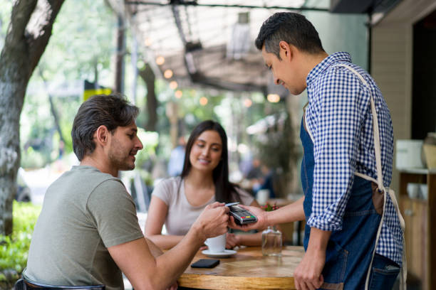istock Man at a restaurant making a contactless payment 1344979770