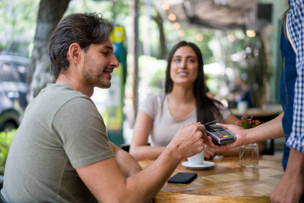 istock Man at a cafe making a contactless payment with his credit card 1344979776