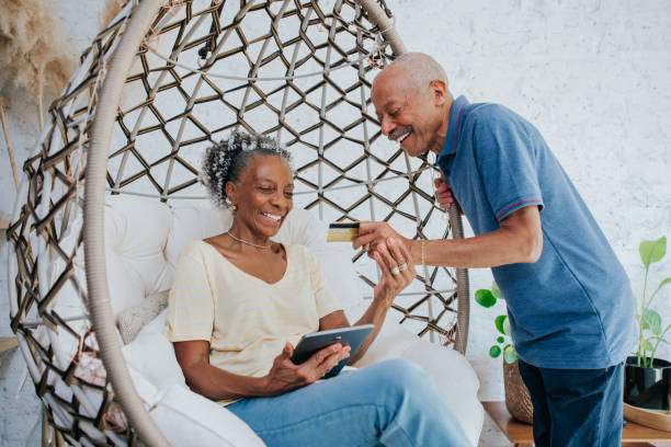 istock Senior couple using smartphone and credit card to purchase online 1344980667