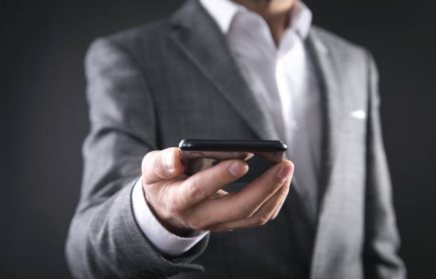 istock Businessman holding smartphone in office. 1344983100
