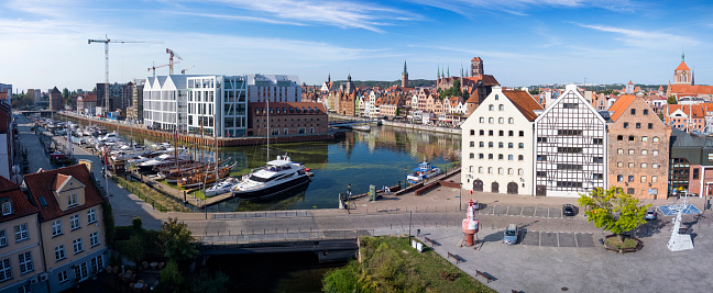 The classic view of Gdansk Old Town with the historical hanseatic-style buildings and modern hotels  over Motlawa river, Poland