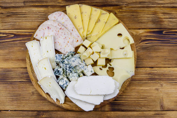 istock Cheese platter with different kinds of cheese on wooden table. Top view 1344987429