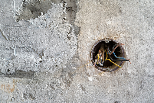 Wires for a socket in a wall covered with plaster. home renovation electricity concept