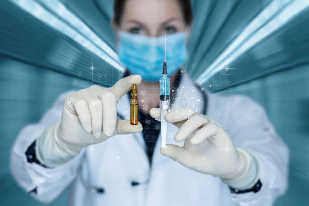 Doctor shows a syringe with a vaccine .
