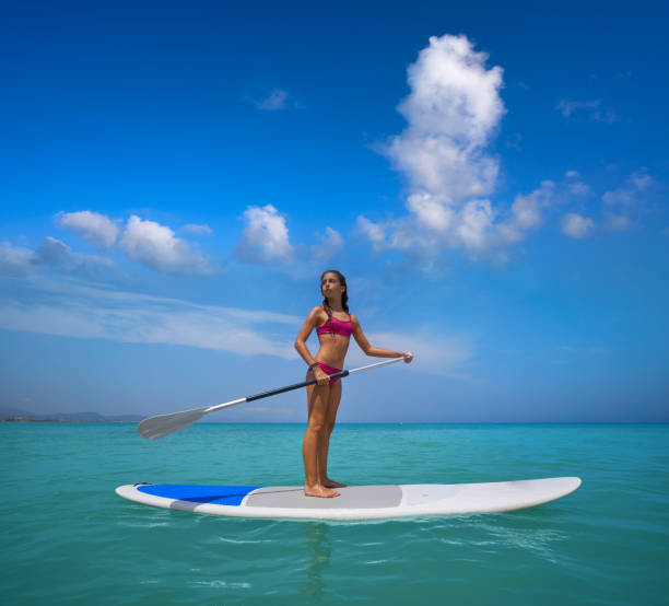 istock Girl standing on paddle surf board SUP 1344988808