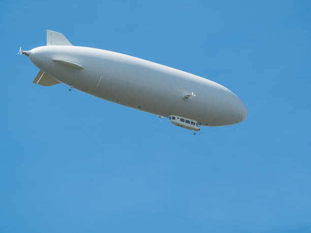 istock Airship flying in clear blue sky 1344990811