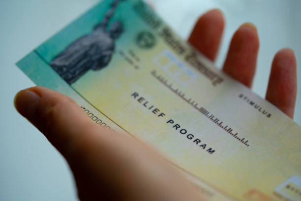 istock Stimulus American rescue program check in hand. Close up view. 1344992283