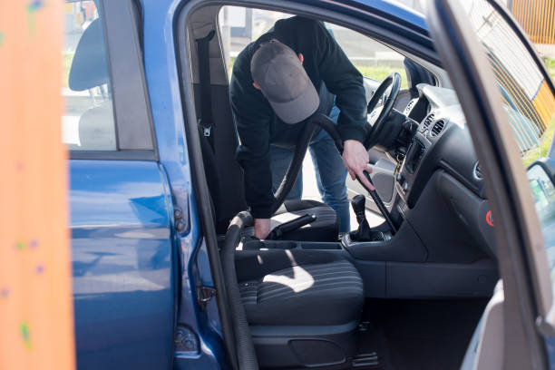 istock Young man cleaning his car with a vacuum cleaner 1344993780