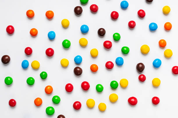 istock Scattering of multicolored chocolate pills background 1344993947