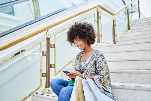 istock Afro woman with mobile phone shopping. 1344994738