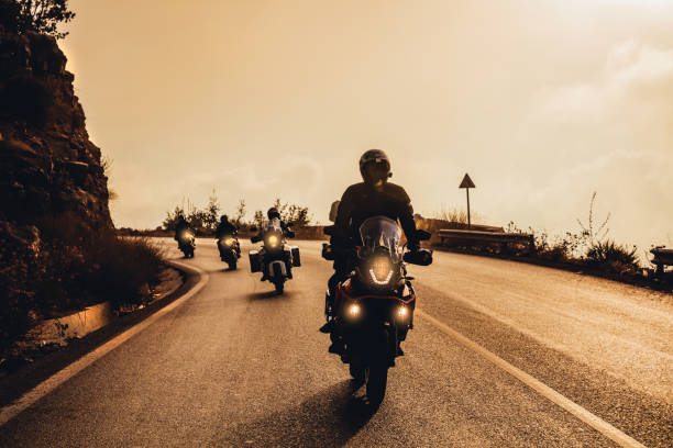 Bikers on Sunset in the Mountains Group of Motorbikers Riding on Motorcycles along Mountainous Road in Mild Sunset Light. Extreme Sport. Active Life. bikers stock pictures, royalty-free photos & images