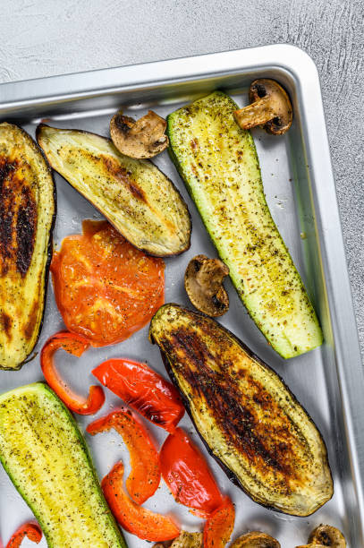 istock Roasted vegetables on a baking pan. White background. Top view 1344995160