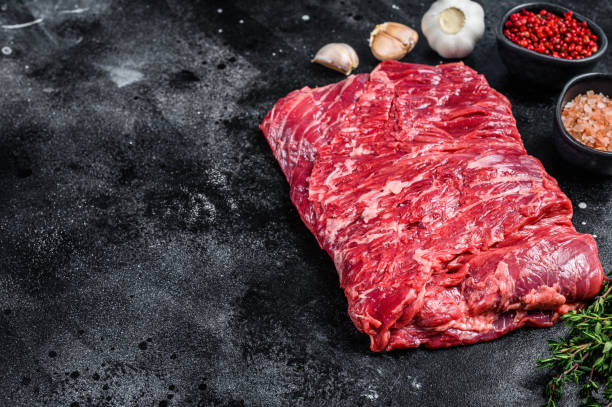 istock Raw fresh marble beef brisket meat with herbs. Black background. Top view. Copy space 1344995470