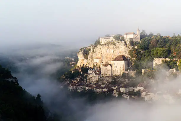 Medieval village of Rocamadour by a misty and sunny day. In the middle ages, pilgrims come here and ascend 216 steps on their knees to go to the shrine of Our Lady at the top of the cliff.