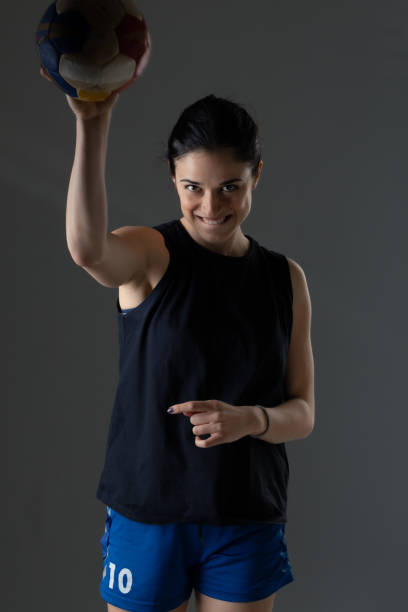 istock Handball player posing on dark gray background. Girl posing with ball. 1344998437