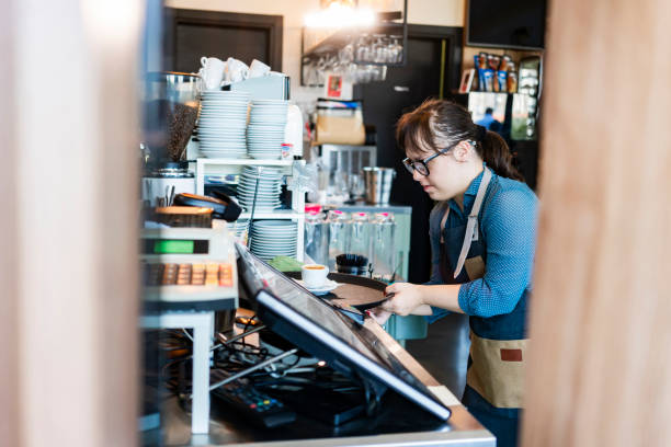 istock Young woman with Down Syndrome working at cafe 1344998530