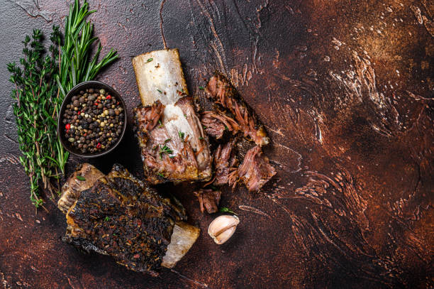istock BBQ Grilled short beef ribs on a kitchen table. Dark background. Top view. Copy space 1345000173