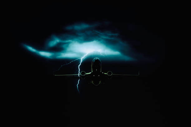 istock Airplane is flying in dark night sky with lightning in background 1345000321