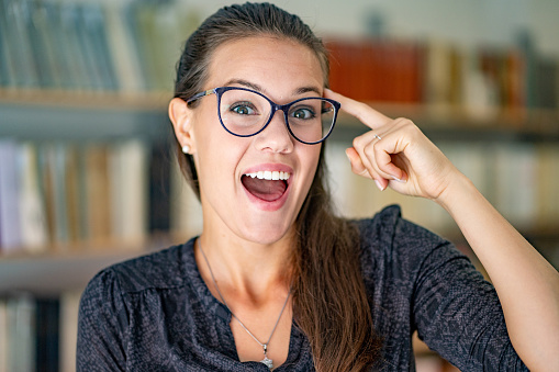 Young Excited woman portrait in a Library