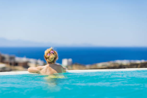istock Woman enjoying view from endless swimming pool 1345007167