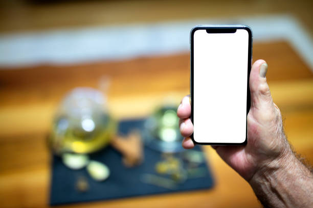istock Hand Holding Blank Smartphone at home 1345008346
